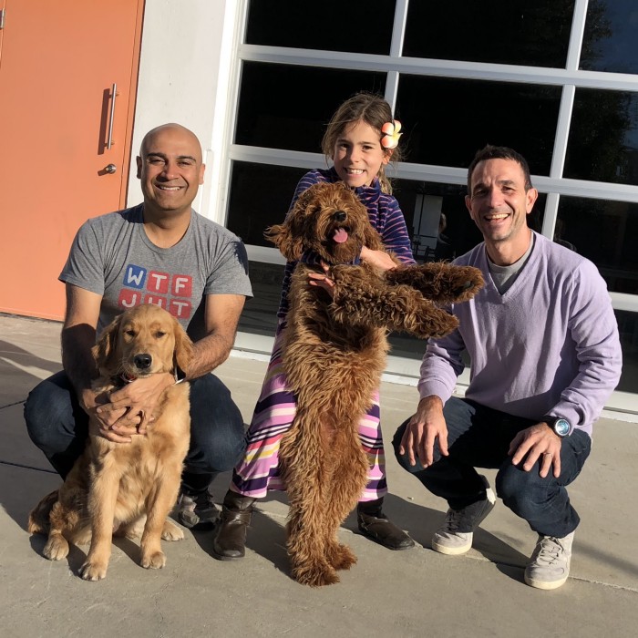 Dr. Manu Kumar and Villi Iltchev with a golden retriever and a golden doodle dog