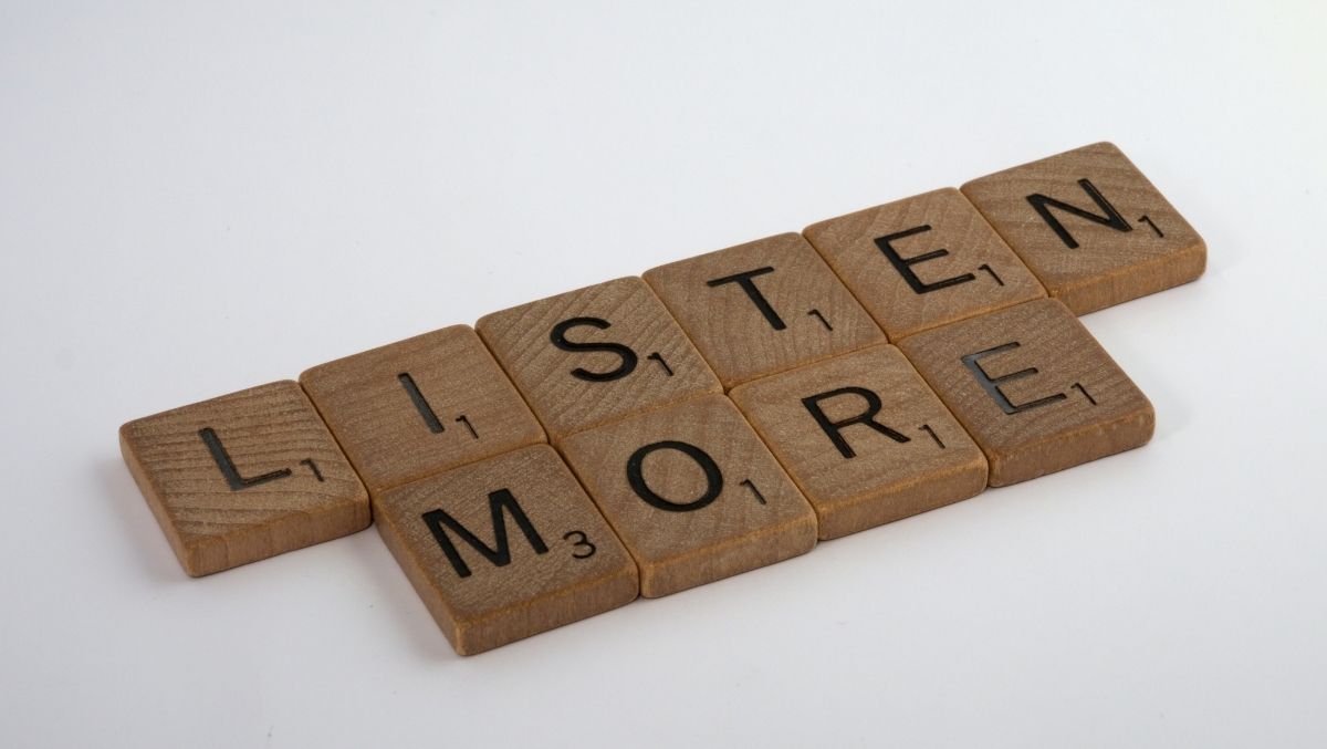 Scrabble tiles spelling "Listen More"